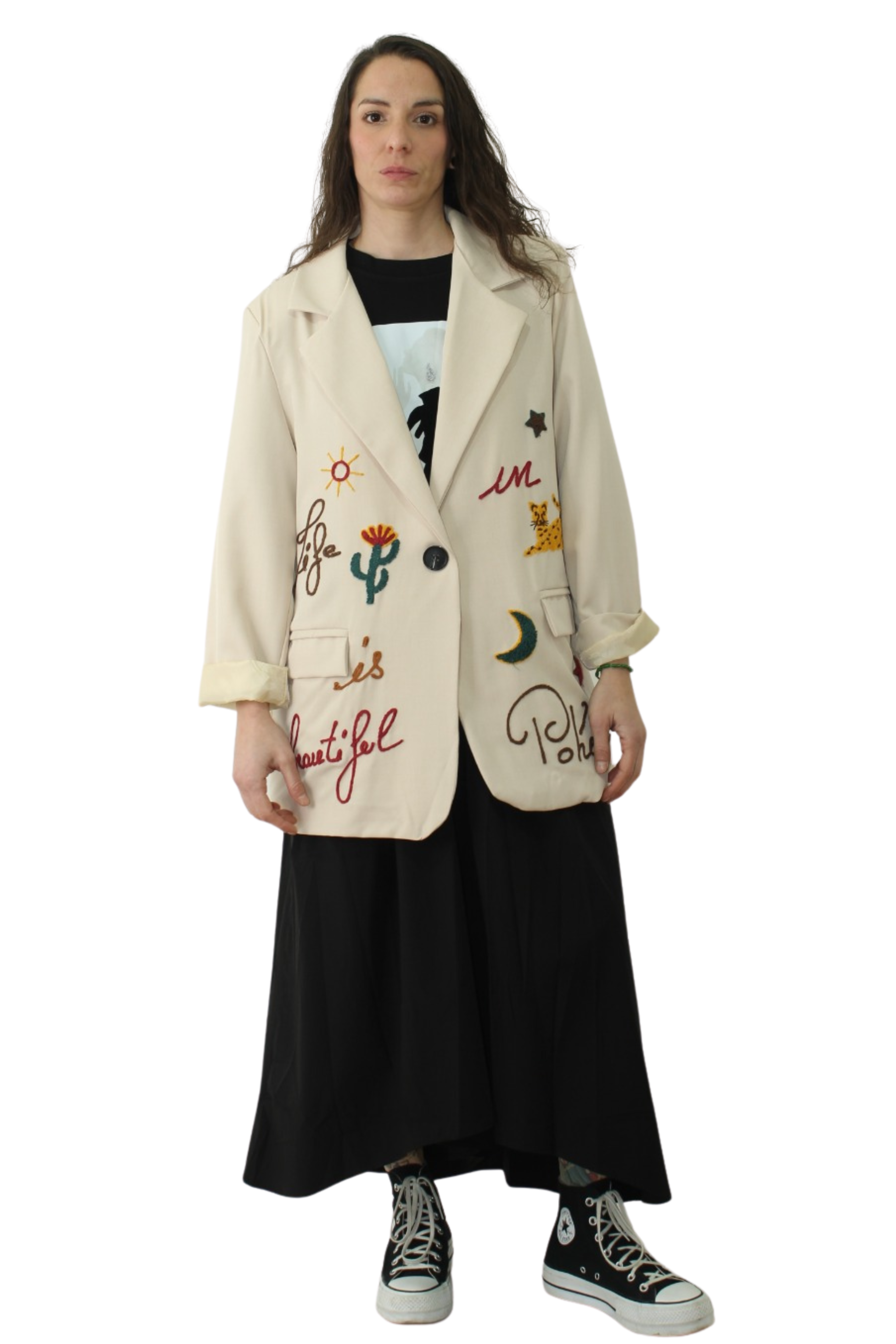 mujer con blazer beige con detalles de cactus, texto símbolos bordados con colores LYKKE