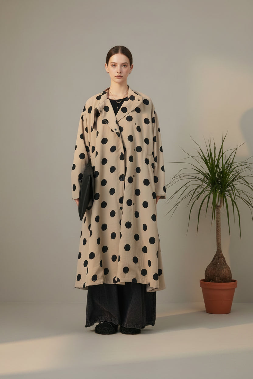 modelo recta con gabardina beige de lunares negros y maxi bolso en la mano