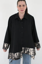 Chaqueta asimétrica negra con estampado beige cerrada con botones delantero LYKKE