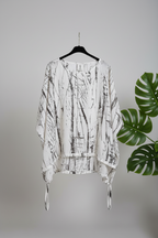 camisa yolykke con las mangas murciélago en blanco y jaspeado en negro asimétrica y ajustable de la cintura