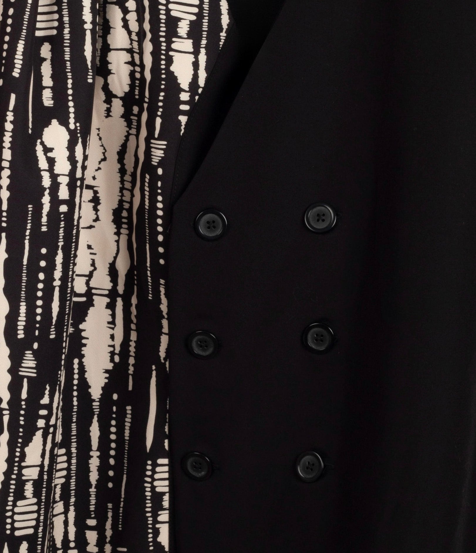 Chaleco asimétrico en negro con estampado latera beige cerrado con botones LYKKE