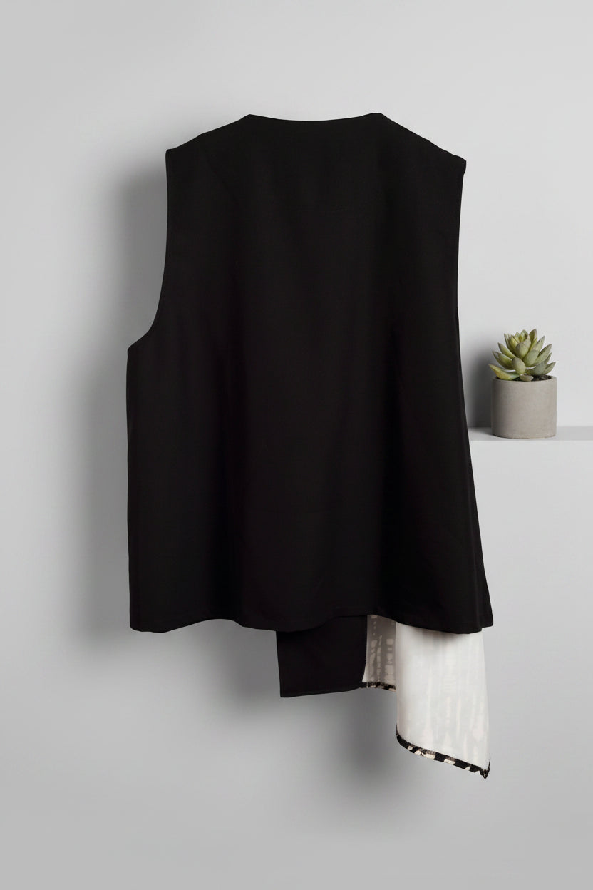 Chaleco asimétrico en negro con estampado latera beige cerrado con botones LYKKE