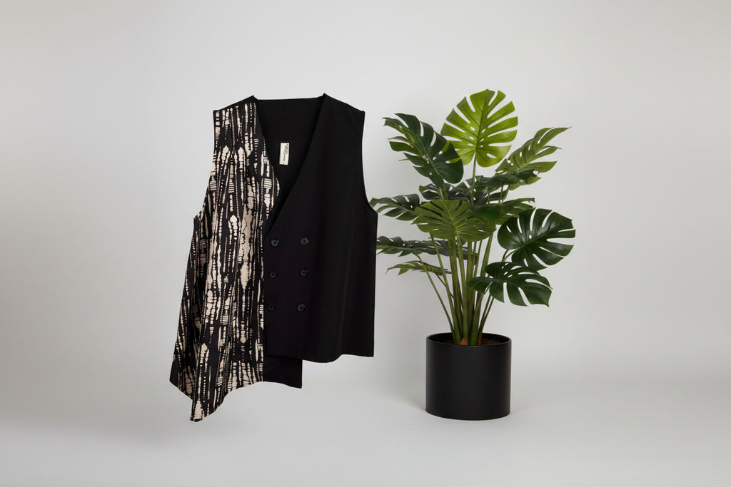 Chaleco asimétrico en negro con estampado latera beige cerrado con botones LYKKE