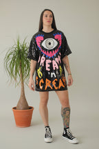 Vestido de lentejuelas negro con ojo delante de colores en blanco rosas amarillos y naranjas LYKKE